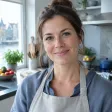 Portret van een vrouw met een linnen schort in een lichte keuken