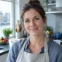 Portret van een vrouw met een linnen schort in een lichte keuken